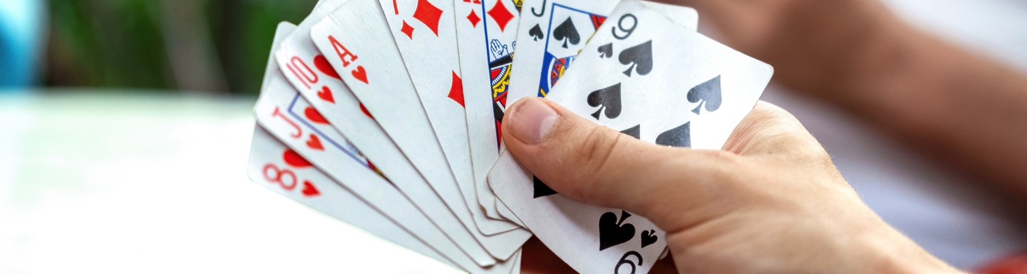 man-playing-cards-with-other-people-holding-deck.jpg - CC Val Essonne